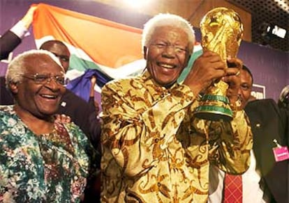 Mandela, que cumple su sueño de que Suráfrica sea el primer país africano en albergar el evento, alza la copa.