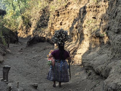 Una mujer lleva un leña sobre su cabeza en Guatemala.