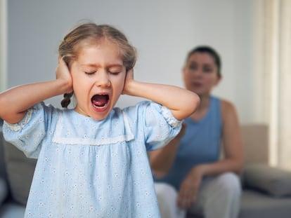 Una niña ignora a su madre mientras le regaña.