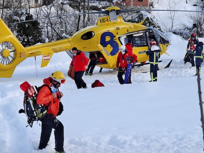 Rescatistas del Servicio de Emergencias de Asturias junto al helicóptero medicalizado de Bomberos de Asturias, que ha sobrevolado este miércoles la zona del alud.