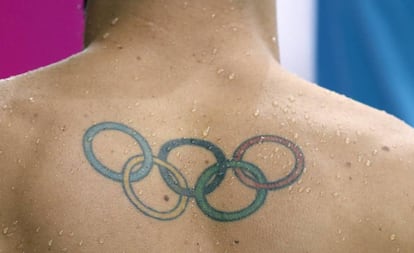 Tatuaje del logo olímpico en la espalda de un atleta.