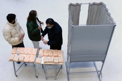 Tres personas preparan su papeleta en un colegio electoral de Valladolid.