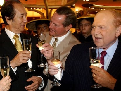 Ho (corbata dorada) y Adelson (corbata morada) brindan tras la apertura de un casino del segundo en Macao en 2004.