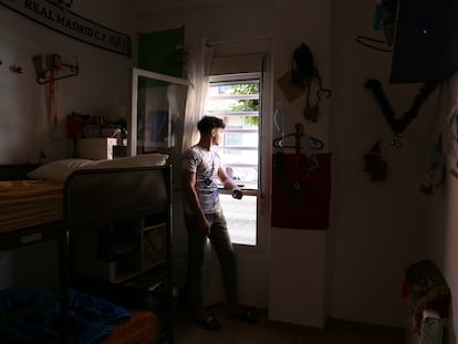 Omar Kordala mira por la ventana de su habitación en el piso tutelado donde vive en el barrio de Usera en Madrid, en julio de 2021.