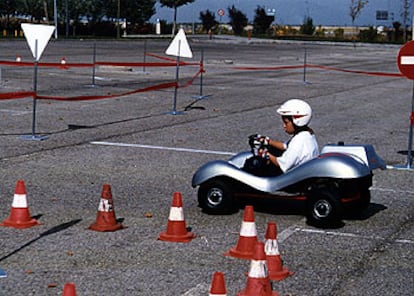 Un niño conduce un <i>kart</i> en un circuito durante el desarrollo de un curso de seguridad vial infantil organizado por la casa de automóviles Audi.