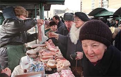 Varios ancianos compran cerdo en un mercado callejero de Moscú.