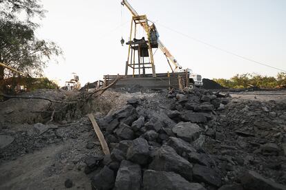 Los mineros estaban faenando a 60 metros de profundidad cuando se encontraron con un flujo de agua subterránea que provocó que el túnel se viniera abajo. En la imagen, una grúa apoya en las labores de rescate.
