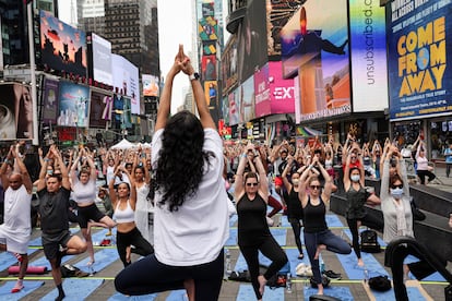 La gente participa en el 'Solstice in Times Square: Mind Over Madness Yoga' para celebrar el solsticio de verano en Nueva York, este martes.