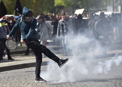 A protester kicks a tear gas canister back to anti-riot police (not pictured) during clashes within a demonstration against the French government's proposed labour reforms on April 28, 2016 in Nantes.  
Protests turned violent in Paris and other French cities today as tens of thousands of workers and students made a new push for the withdrawal of a hotly contested labour bill. / AFP PHOTO / LOIC VENANCE