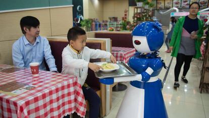 Un robot camarero atiende a unos clientes en un restaurante de Kunsham, China, donde trabajan 10 androides.