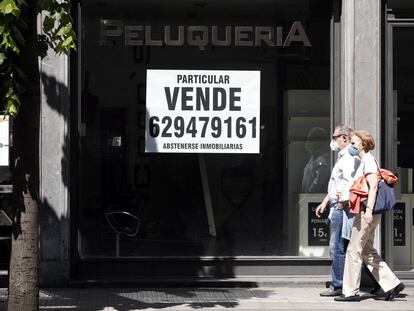 Varios viandantes pasan por delante de un local comercial de Bilbao en venta, el pasado mes de mayo.