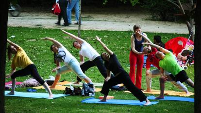 Gente practicando yoga en El Retiro