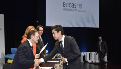 El director de la Fundación La Caixa, Jaume Giró, entrega la beca a uno de los investigadores seleccionados