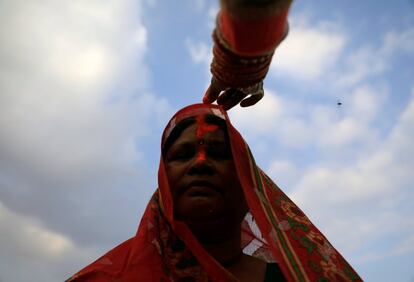 Ofrecimiento de una 'tika' a una devota durante las oraciones al sol poniente en el festival 'Chhat', celebrado en la orilla del río Bagmati, en Katmandú (Nepal).