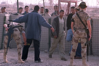 Soldados españoles cachean a civiles iraquíes en la base española de Diwaniya, en 2003.