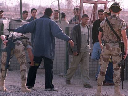 Soldados españoles cachean a civiles iraquíes en la base española de Diwaniya, en 2003.