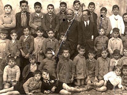 Severiano Núñez, con gafas, el maestro fusilado en Plasencia, junto a su colega y los niños de la escuela.