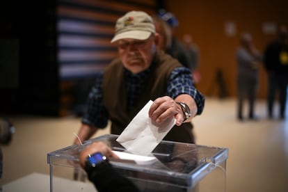 Un hombre deposita su voto en una urna este domingo en el Centro Cultural La Roca del Vallès de Barcelona.