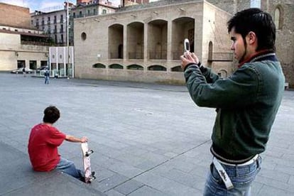 Un joven saca una fotografía con un teléfono móvil en Barcelona.