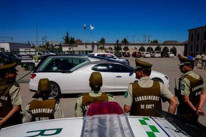 Policías observan al carro fúnebre entrando al Cementerio Canaán, en Santiago.