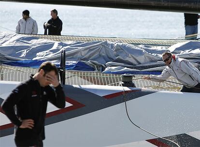 Miembros de la tripulación del Alinghi recogen el material del equipo.