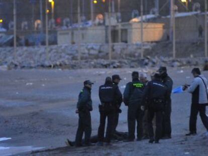 Agentes de la Guardia Civil rodean el cad&aacute;ver del d&eacute;cimo subsahariano fallecido en el paso de Ceuta que ha aparecido. 