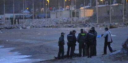 Agentes de la Guardia Civil rodean el cad&aacute;ver del d&eacute;cimo subsahariano fallecido en el paso de Ceuta que ha aparecido. 