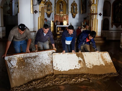 Vecinos colaboran con las labores de limpieza de la Iglesia de la Encarnación en Benamargosa, este jueves. 