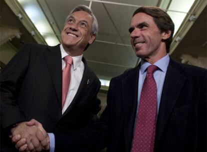 Sebastián Piñera estrecha la mano del ex presidente español durante un acto este miércoles en Santiago.