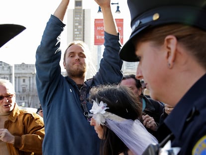 David DePape, center, records Gypsy Taub being led away by police after her nude wedding outside City Hall on Dec. 19, 2013, in San Francisco.