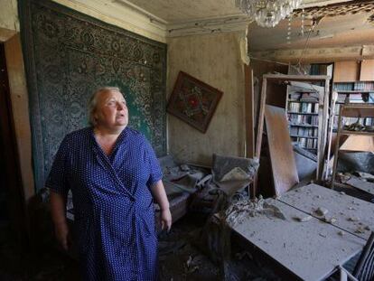 Una mujer muestra los da&ntilde;os que su vivienda ha sufrido en los ataques en Donets, este domingo.