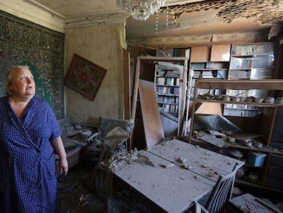 Una mujer muestra los da&ntilde;os que su vivienda ha sufrido en los ataques en Donets, este domingo.