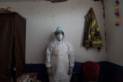Fernando de la Rosa posa con un traje epidemiológico en el despacho del comandante de la estación de bomberos, Adolfo Oribe. El hombre, de 25 años, se dedica a apoyarles en el Valle de Chalco desde 2019, cuando hizo el cursillo de paramédico. Vive en Xochimilco y es albañil.