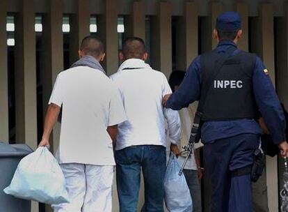 Un policía escolta a dos de los guerrilleros de las FARC trasladados a la prisión de Chiquinquira