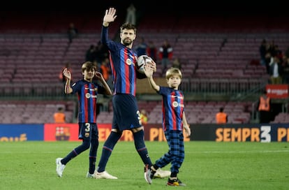 Gerard Piqué y sus hijos Milan y Sasha saludan a los seguidores al final del partido contra el Almería. Ambos han acompañado a su padre en su último día en el Camp Nou.