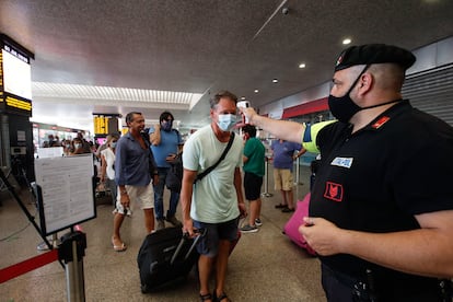 An official measures passengers' temperature at the Termini railway station in Rome.