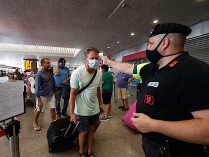 An official measures passengers' temperature at the Termini railway station in Rome.