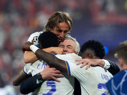 Modric, Militão y Vinicius abrazan a Ancelotti después de ganar la final de la Champions en París.