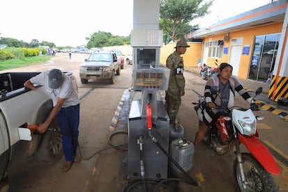 Un hombre llena su vehículo de gasolina mientras la gente hace cola en una gasolinera en Cuatro Canadas, el 11 de marzo.