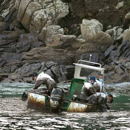 Marineros gallegos recogen fuel del <i>Prestige</i> en su barca junto a las islas Cíes.