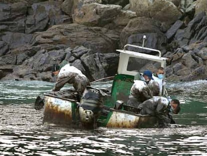 Marineros gallegos recogen fuel del <i>Prestige</i> en su barca junto a las islas Cíes.