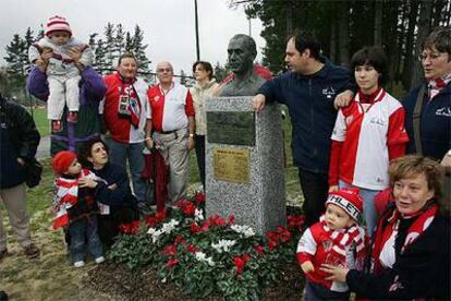 Aficionados rojiblancos de distintas generaciones posan junto al busto de Zarra en Lezama.