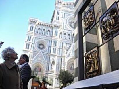 Una mujer observa los tres paneles de la puerta norte del baptisterio de Florencia que van a formar parte de un proyecto de restauración en el año 2013, según se anunció hoy 7 de noviembre de 2012. En ellos se representa "La entrada en Jerusalén" (izda, arriba), "Anunciación" (i) y "El Bautismo de Cristo" (d).