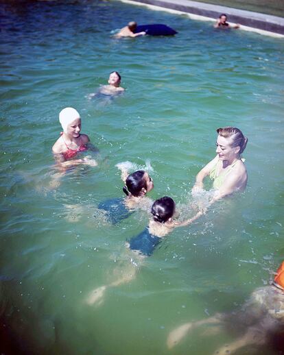 Joan Crawford (1905 – 1977), en una piscina con las gemelas que adoptó, Cindy and Cathy, en 1950.