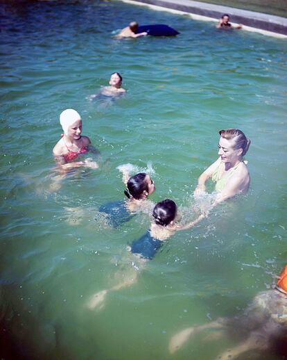 Joan Crawford (1905 – 1977), en una piscina con las gemelas que adoptó, Cindy and Cathy, en 1950.