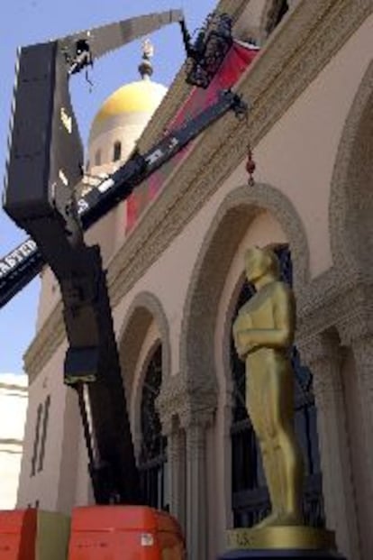 Una grúa coloca ayer una gran estatua del Oscar frente al Auditorium Shrine.