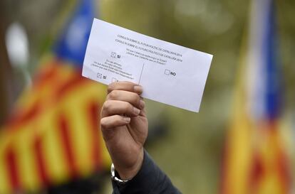 Un hombre sostiene una papeleta simbólica de la consulta sobre la independencia de Cataluña.