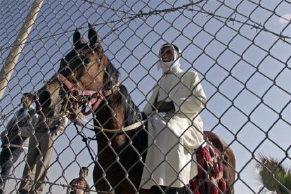 Los palestinos controlarán por primera vez un paso fronterizo, aunque los israelíes mantendrán cierta supervisión sobre la zona. De hecho, a escasos kilómetros está el cuartel de Kerem Shalom, desde donde controlarán por circuito cerrado de televisión el tránsito fronterizo, lo cual disgusta a las organizaciones radicales palesinas. En la imagen, un policía palestino a caballo inspecciona la valla que separa Gaza de Egipto.