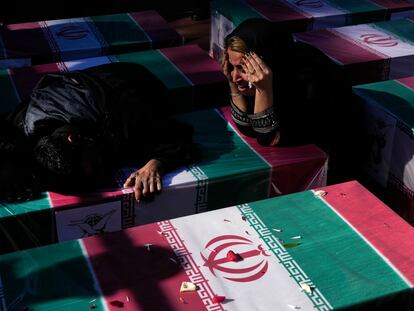 Dos mujeres lloraban el pasado viernes sobre el ataúd de un ser querido, durante la ceremonia fúnebre que se celebró en la ciudad iraní de Kermán.