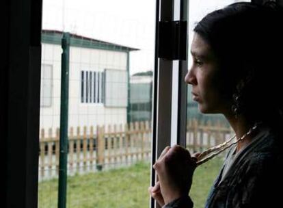 Una mujer mira por la ventana de su casa en el poblado gitano de Collatina, cerca de Roma.